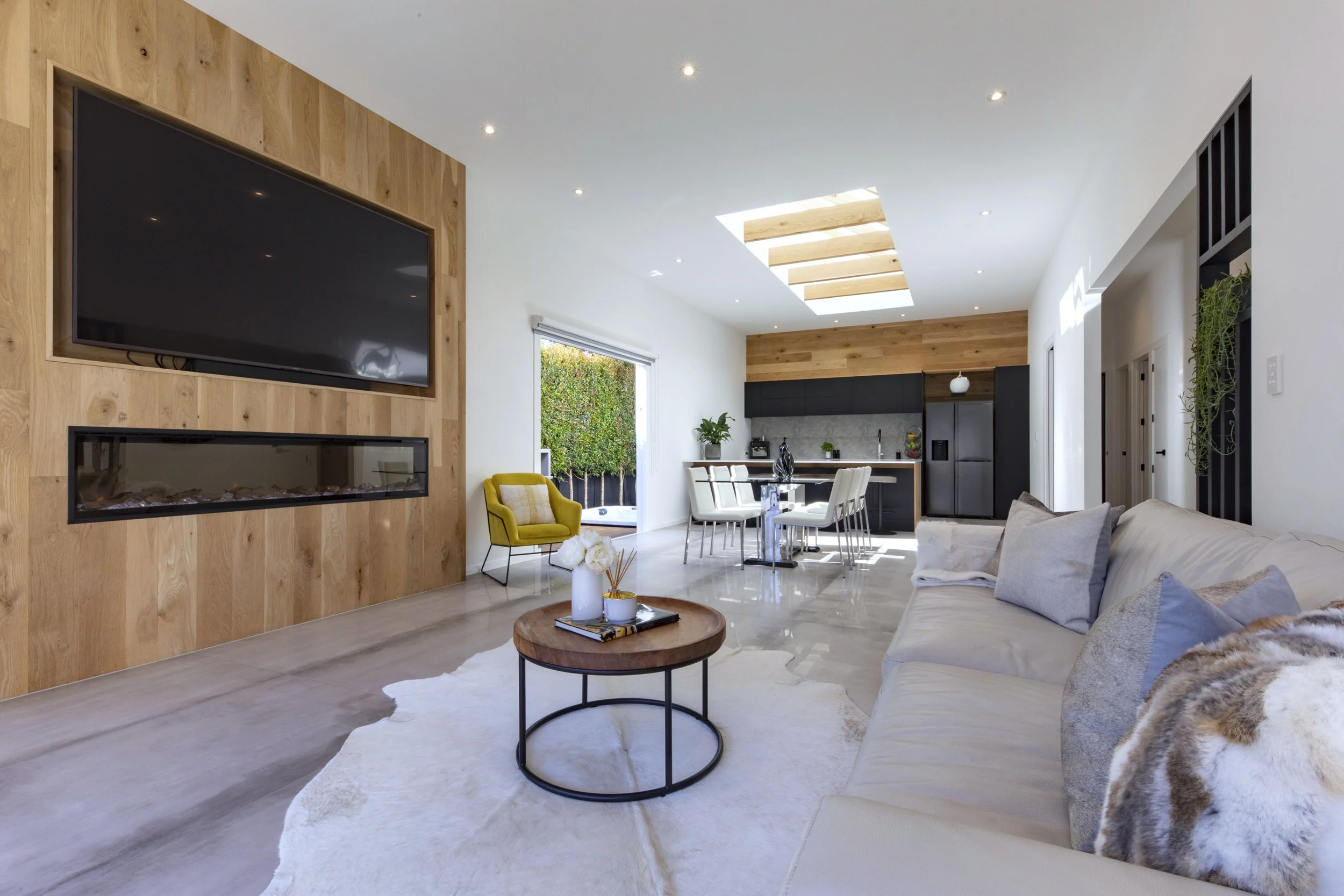 Living area with timber feature wall, fireplace, and polished concrete floors